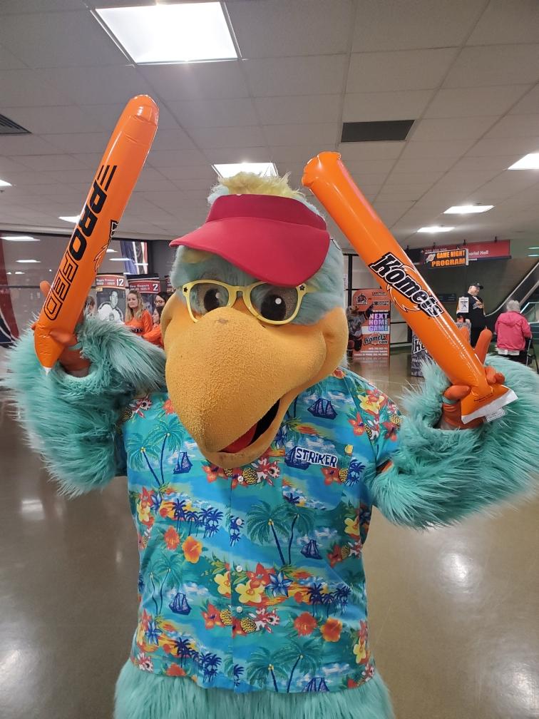 A mascot dressed up in a Hawaiian shirt with thundersticks.